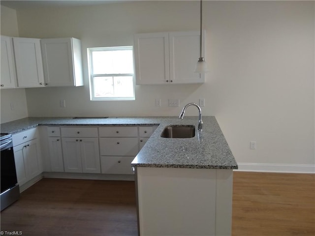 kitchen with hardwood / wood-style flooring, white cabinets, sink, and light stone counters