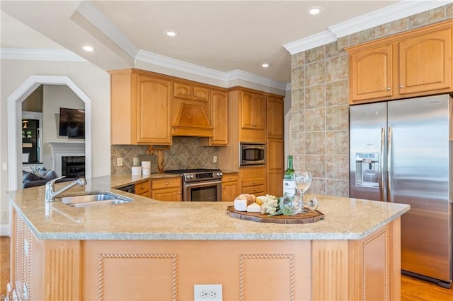 kitchen with light stone countertops, a peninsula, a sink, custom range hood, and appliances with stainless steel finishes