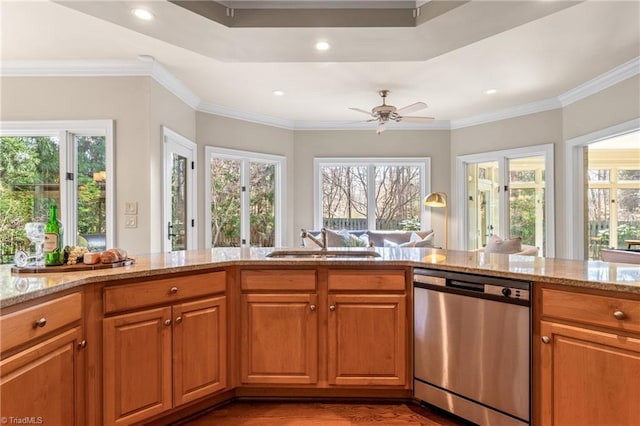 kitchen featuring stainless steel dishwasher, a healthy amount of sunlight, light stone countertops, and a sink