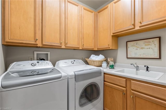 clothes washing area featuring a sink, cabinet space, and washing machine and clothes dryer