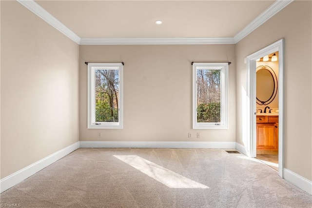 unfurnished room featuring a wealth of natural light, baseboards, carpet floors, and crown molding