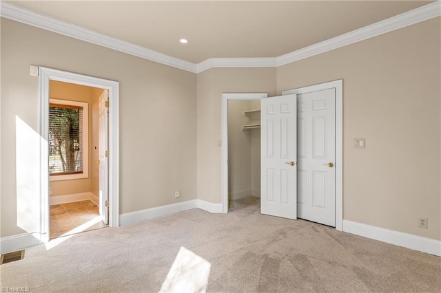 unfurnished bedroom with visible vents, ornamental molding, baseboards, and carpet floors