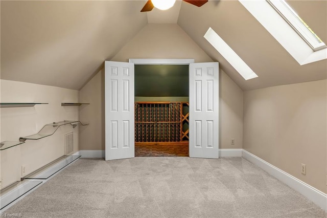 additional living space featuring baseboards, carpet, ceiling fan, and lofted ceiling with skylight