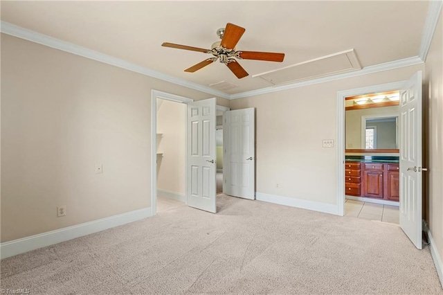 unfurnished bedroom featuring attic access, light colored carpet, baseboards, and ornamental molding