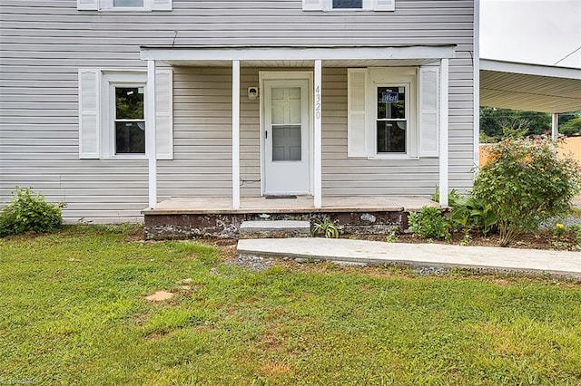 view of exterior entry featuring a lawn