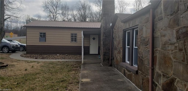 157 W Brocktown Rd, Moravian Falls, NC 28654 - property entrance featuring stone siding, a metal roof, a chimney, and a lawn