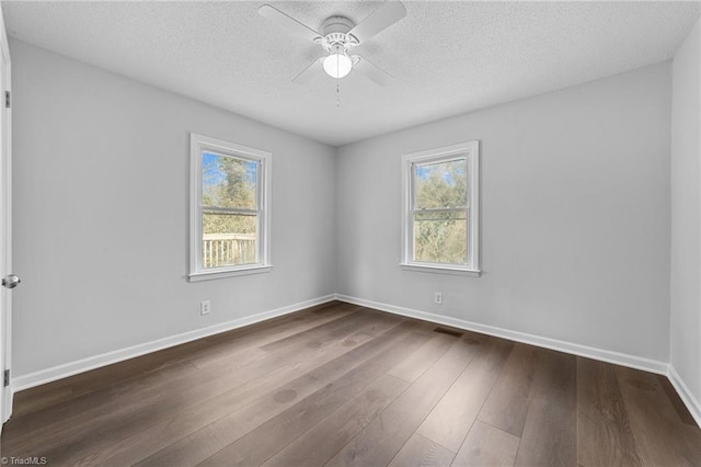 empty room featuring ceiling fan, dark hardwood / wood-style floors, and a textured ceiling