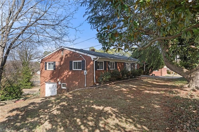 view of property exterior with a garage, brick siding, and a chimney