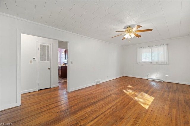 empty room featuring visible vents, crown molding, and hardwood / wood-style floors