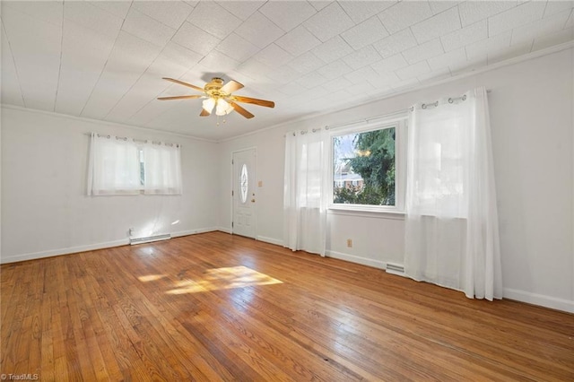 empty room with wood-type flooring, a healthy amount of sunlight, and baseboards