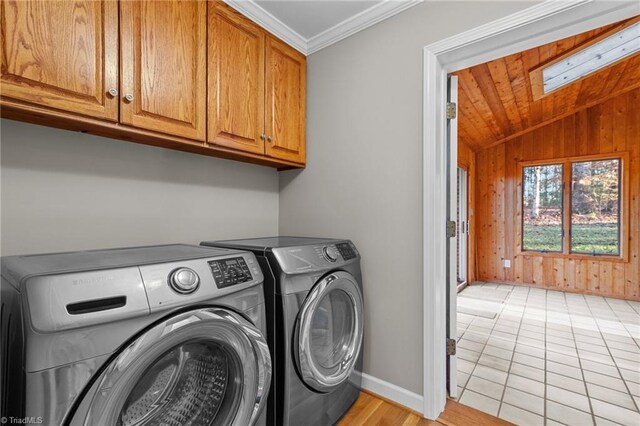 clothes washing area featuring wood walls, cabinets, a skylight, ornamental molding, and light tile patterned flooring