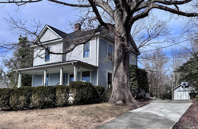 view of front of property with a garage, an outbuilding, and covered porch