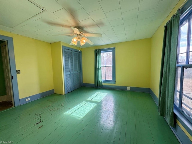 unfurnished bedroom featuring wood-type flooring, ceiling fan, and a closet