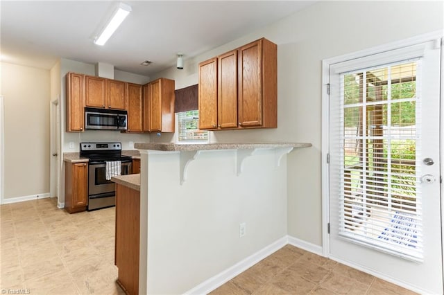 822 Blue Lake Dr, Mebane, NC 27302 - kitchen with stainless steel appliances, a kitchen bar, healthy amount of natural light, and light countertops