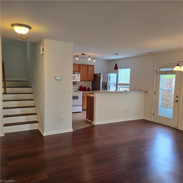 unfurnished living room with stairs, baseboards, and dark wood-type flooring
