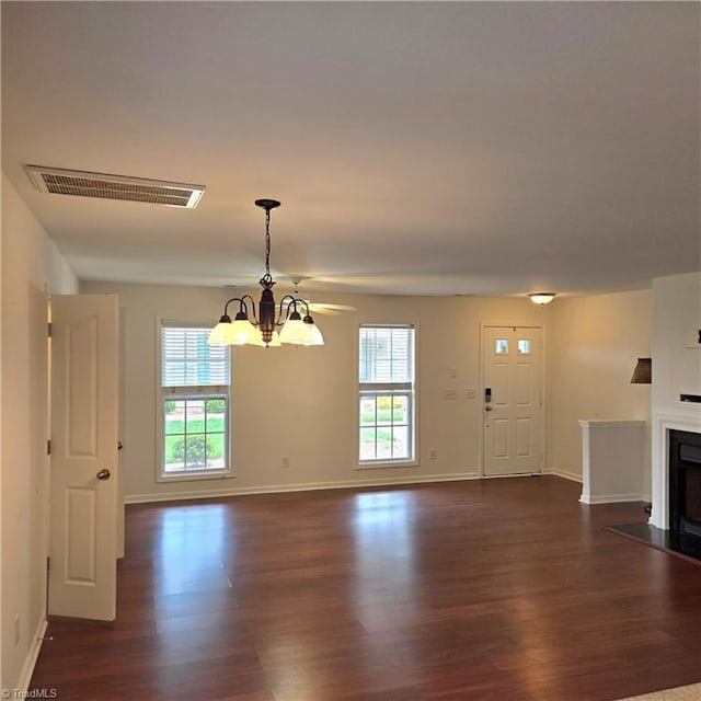 unfurnished living room featuring baseboards, a fireplace with flush hearth, visible vents, and dark wood finished floors