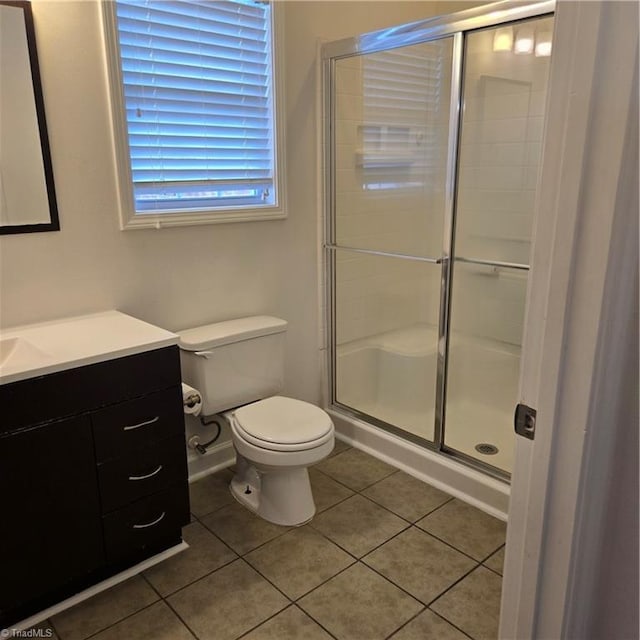 full bathroom featuring a stall shower, tile patterned flooring, vanity, and toilet