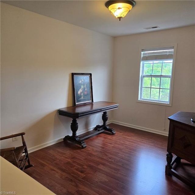 office area with baseboards, visible vents, and wood finished floors