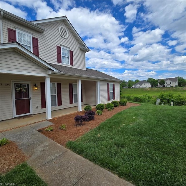 view of front of house featuring covered porch and a front yard