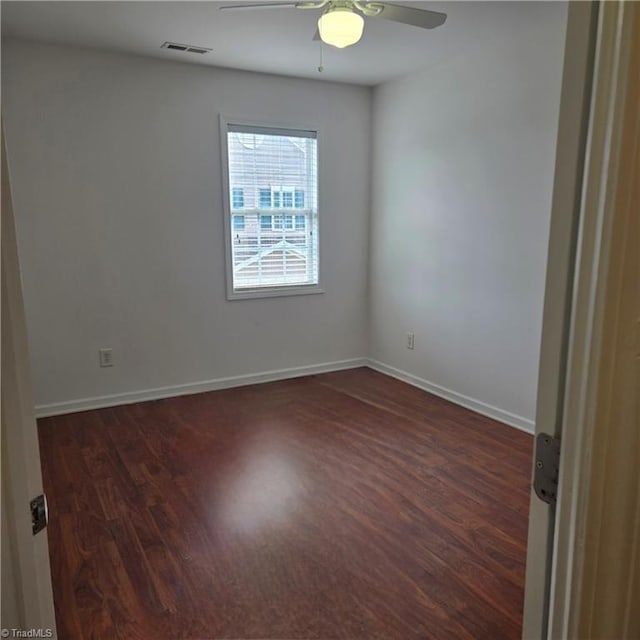 spare room with a ceiling fan, baseboards, visible vents, and wood finished floors