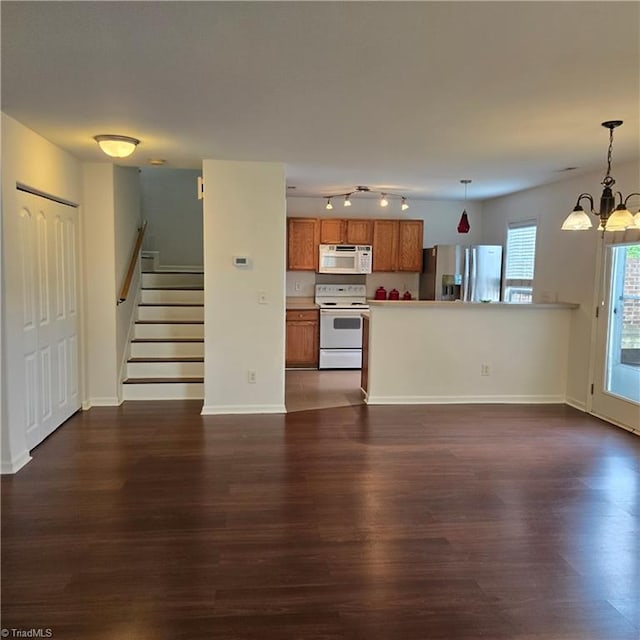 unfurnished living room featuring baseboards, stairway, an inviting chandelier, and dark wood-type flooring