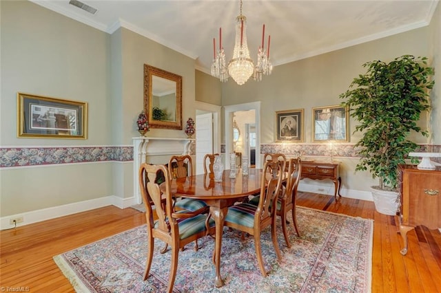 dining room featuring crown molding, a notable chandelier, and hardwood / wood-style flooring