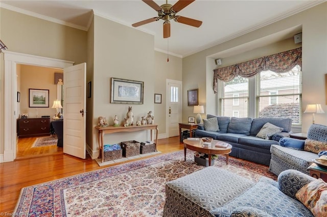 living room featuring hardwood / wood-style floors, ceiling fan, and crown molding