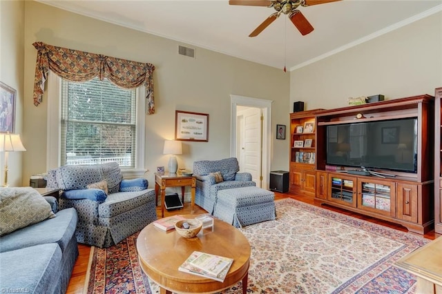 living room featuring hardwood / wood-style flooring, ceiling fan, and ornamental molding