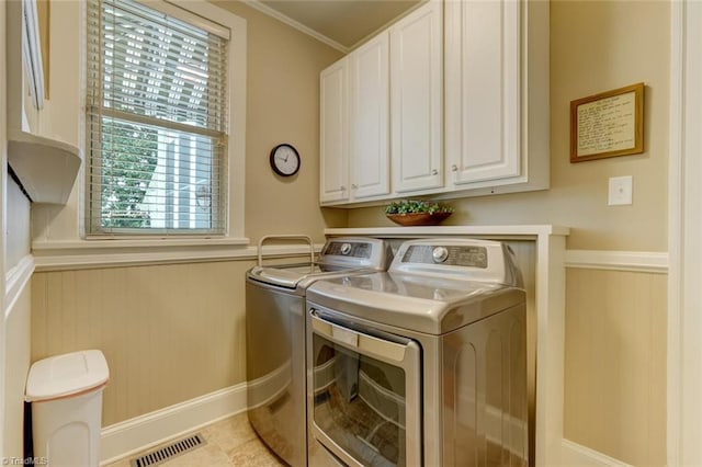 washroom with cabinets, light tile patterned floors, crown molding, and washing machine and clothes dryer