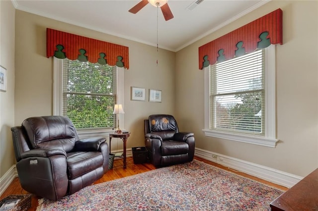 sitting room with a wealth of natural light, crown molding, ceiling fan, and wood-type flooring