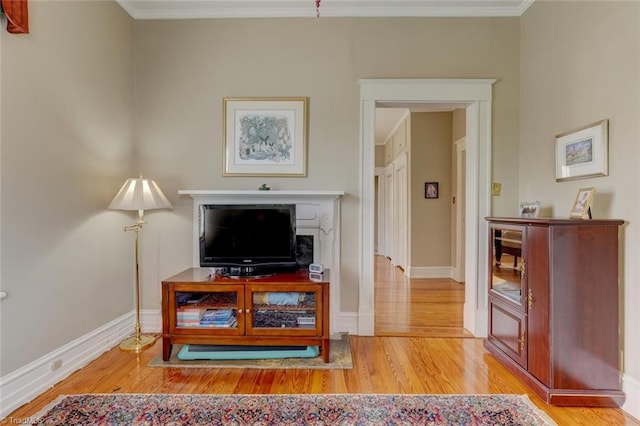 sitting room with light hardwood / wood-style floors and ornamental molding