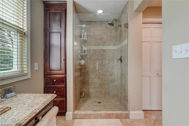 bathroom featuring tile patterned floors, vanity, and a shower with shower door