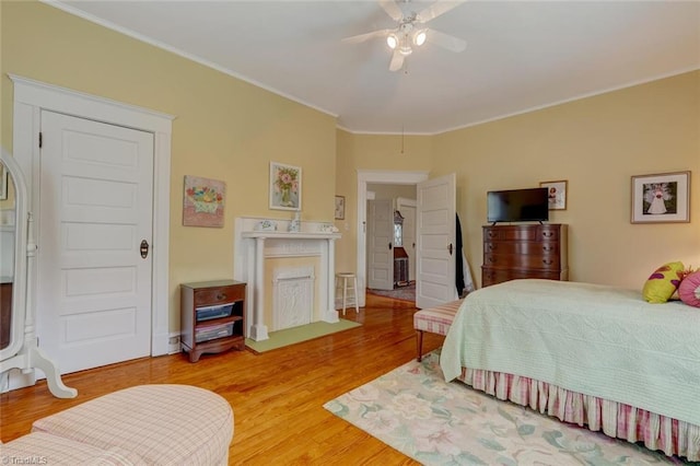 bedroom featuring ceiling fan, hardwood / wood-style floors, and ornamental molding