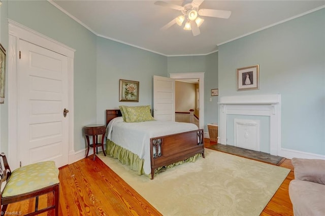 bedroom featuring ceiling fan, wood-type flooring, and crown molding