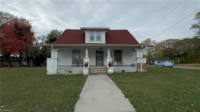 bungalow-style home featuring covered porch and a front lawn