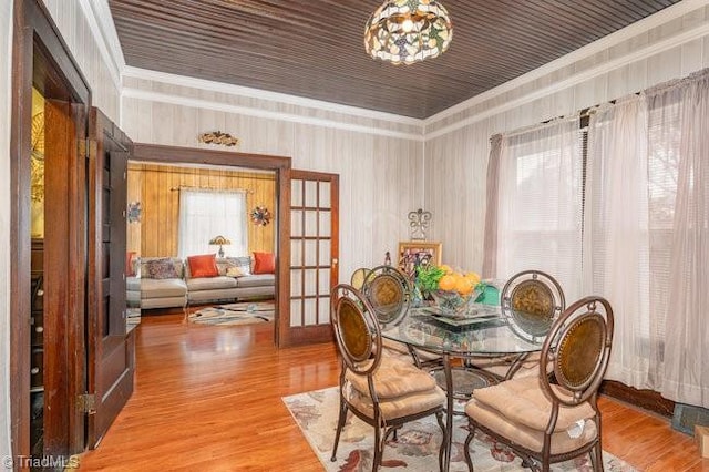 dining room with a chandelier, french doors, wood-type flooring, and ornamental molding