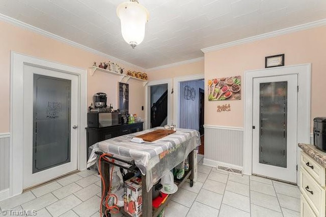 dining space featuring crown molding and light tile patterned floors