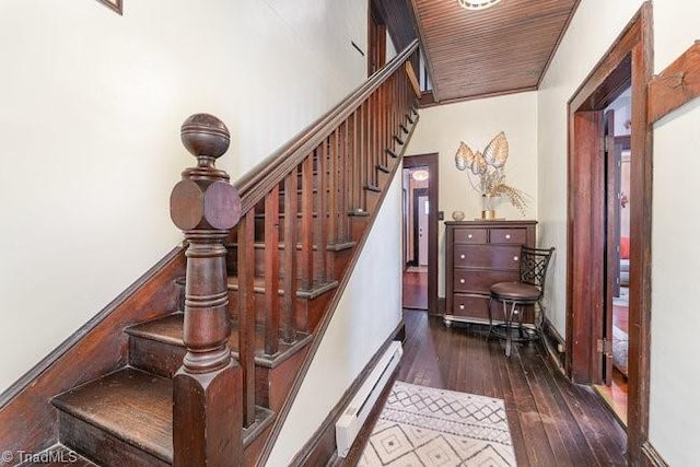 stairs with hardwood / wood-style flooring, wooden ceiling, and a baseboard heating unit