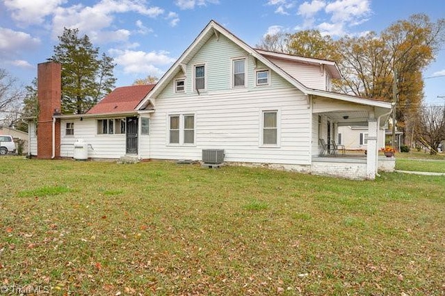 back of property featuring cooling unit and a lawn