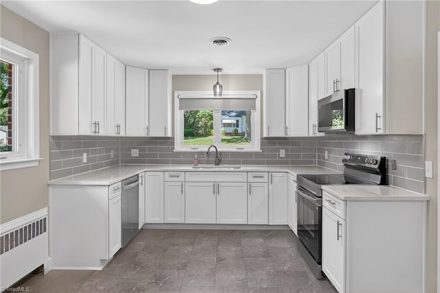 503 Tarleton Ave, Burlington, NC 27215 - kitchen featuring radiator heating unit, appliances with stainless steel finishes, healthy amount of natural light, and white cabinetry