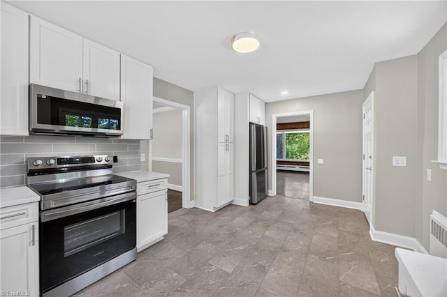 503 Tarleton Ave, Burlington, NC 27215 - kitchen featuring appliances with stainless steel finishes, light countertops, tasteful backsplash, white cabinetry, and recessed lighting