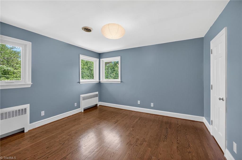 503 Tarleton Ave, Burlington, NC 27215 - spare room with radiator, plenty of natural light, and wood finished floors