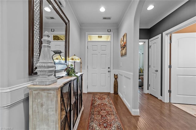 653 Piedmont Crossing Dr, High Point, NC 27265 - foyer with crown molding, dark wood-style floors, a wainscoted wall, arched walkways, and recessed lighting