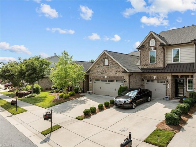 653 Piedmont Crossing Dr, High Point, NC 27265 - view of front of home featuring brick siding, driveway, a shingled roof, and a standing seam roof