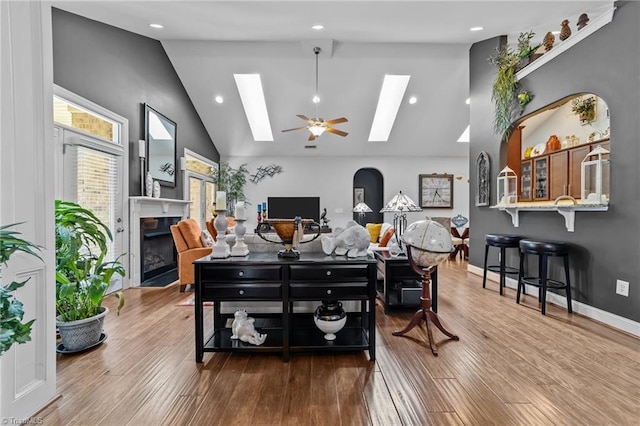653 Piedmont Crossing Dr, High Point, NC 27265 - living room with a skylight, high vaulted ceiling, a tiled fireplace, recessed lighting, and wood finished floors