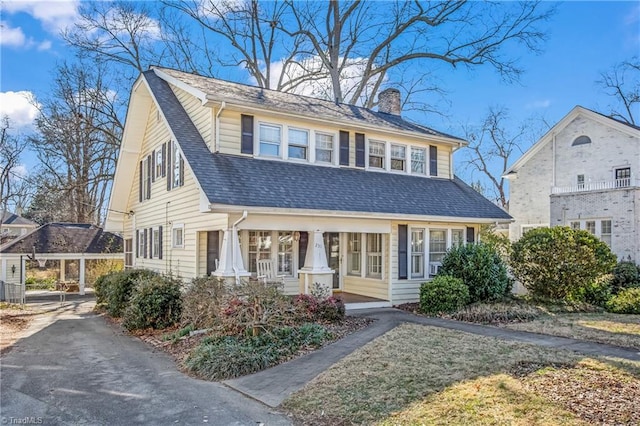 view of front of property with a shingled roof and a chimney