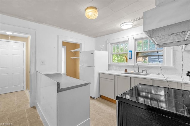 1821 Johnson St, High Point, NC 27262 - kitchen featuring a sink, light tile patterned floors, freestanding refrigerator, black range with electric cooktop, and wall chimney exhaust hood