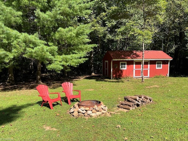 view of yard with a fire pit and an outbuilding