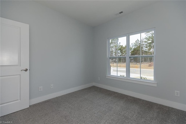 empty room with baseboards, visible vents, and carpet flooring