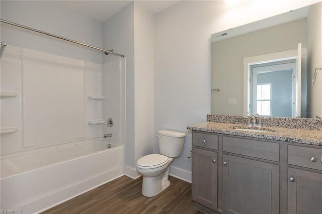 bathroom featuring shower / washtub combination, toilet, vanity, and wood finished floors